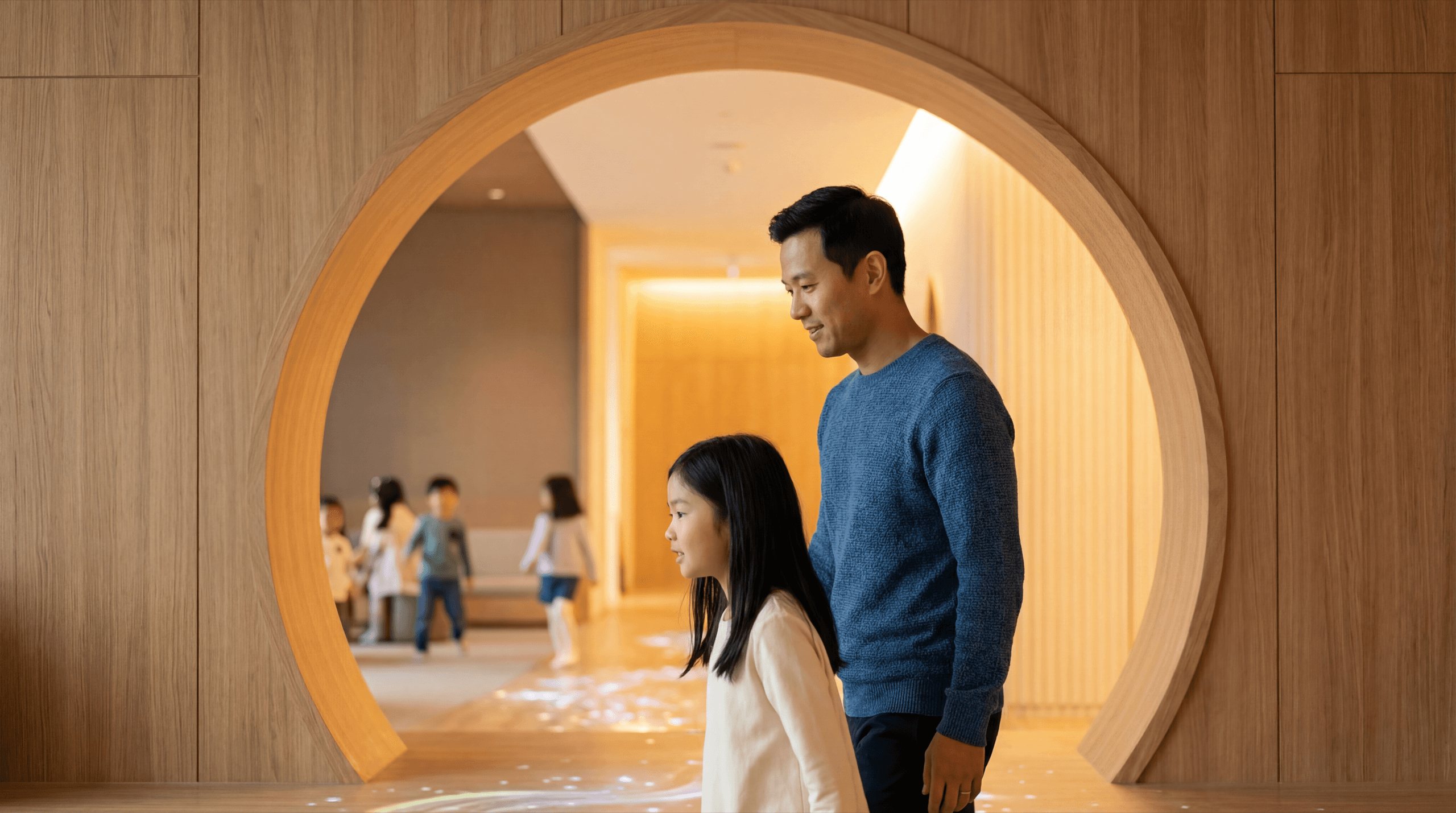 Father and daughter stepping through a circular plywood portal into Luminary